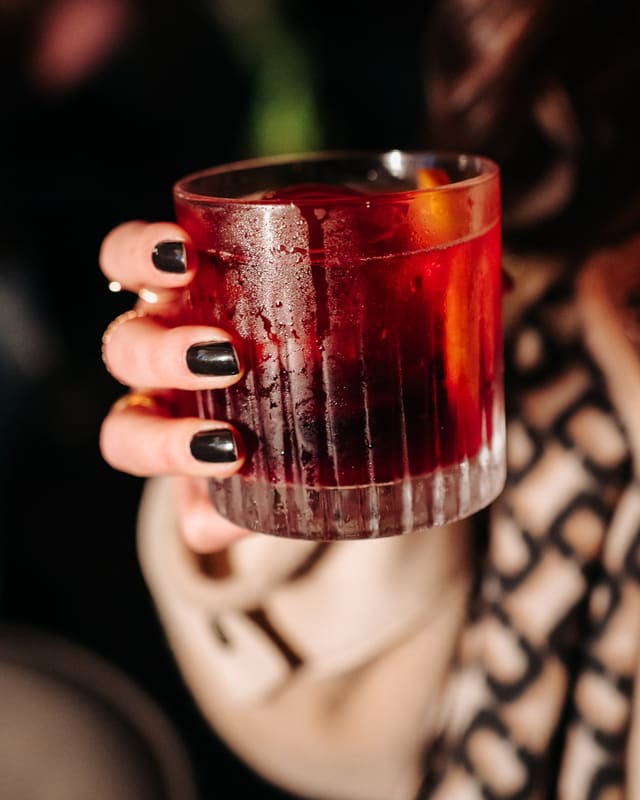 Negroni da casa servido em copo canelado com casca de laranja
